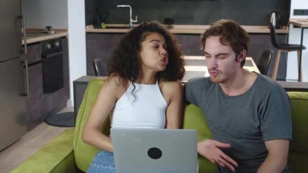 Pár veszekednek, miközben laptopot használnak, miközben otthon ülnek a kanapén. Családi konfliktus, félreértés. Férfiak és nők különböznek.. - Felvétel, videó