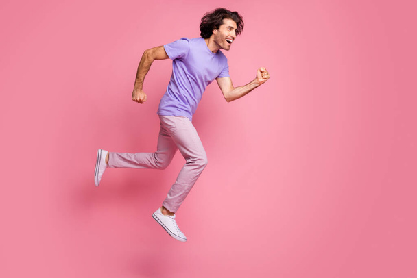 Full body profile side photo of happy guy run sale jump in air wear pink pants isolated on shine pink color background - Foto, imagen
