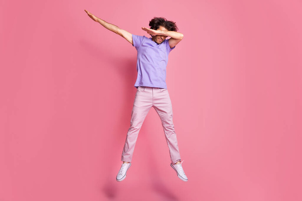 Full length photo of brown haired bristled sportive guy jump up dab cover eyes wear pink trousers isolated on pink color background - Foto, Imagem