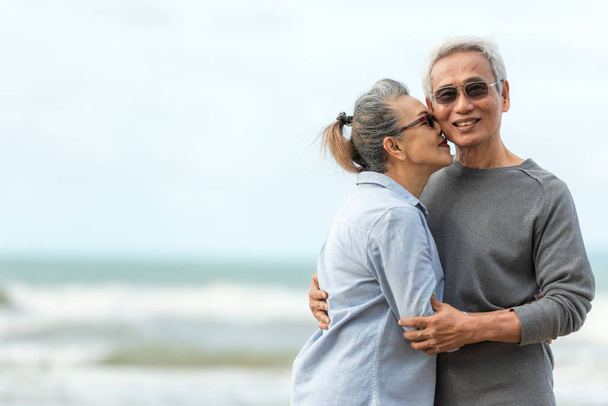 Asian Lifestyle senior couple hug and kiss on the beach happy in love romantic and relax time.  People tourism elderly family travel leisure and activity after retirement in vacations and summer. - Zdjęcie, obraz