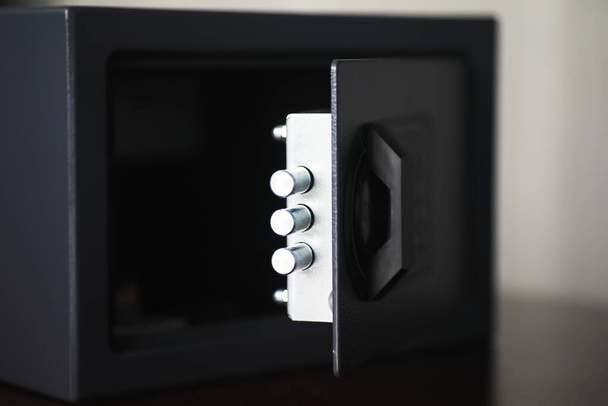 Steel safe with money. Hand putting password in the safety money box in hotel room - Photo, Image