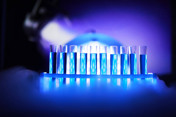 ガラスの試験管が新しい液液をオーバーフローカリウムブルーは、分析反応を行います化学薬品がん製造を使用して様々なバージョンの試薬を取ります  - 写真・画像
