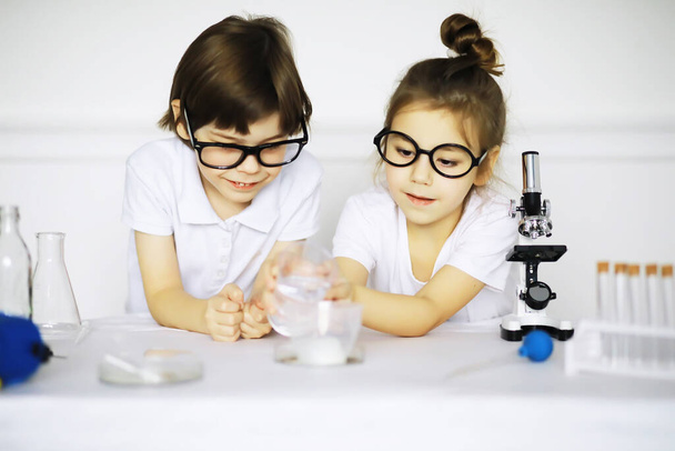 Due bambini carini a lezione di chimica fare esperimenti isolati su backgroun bianco - Foto, immagini