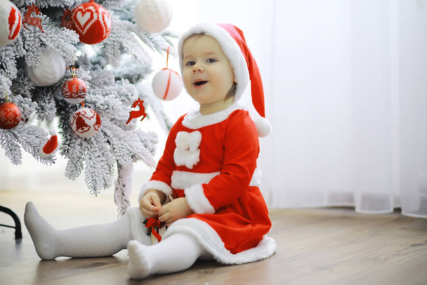 Veselé a veselé Vánoce. Krásné dítě si užije Vánoce. Dětské vzpomínky. Santa Girl malé dítě slaví Vánoce doma. Rodinná dovolená. Dívka roztomilé dítě veselá nálada hrát poblíž vánoční strom. - Fotografie, Obrázek
