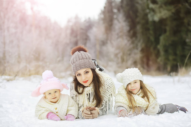 Familia feliz jugando y riendo en invierno al aire libre en la nieve. Parque de la ciudad día de invierno - Foto, Imagen