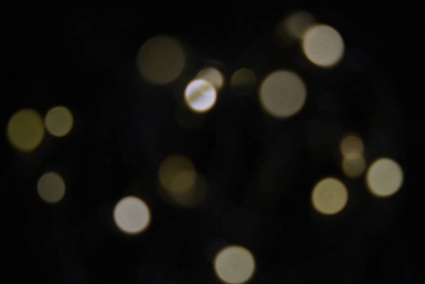 Golden particles bokeh and lens flare on dark background - Фото, изображение