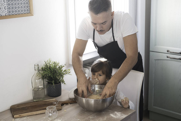 Opiekuńczy tata i słodkie małe przedszkolak córka gotowanie w kuchni razem - Szczęśliwy ojciec i dziewczynka dziecko podejmowania pizzy lub chleb ciasto w domu - Gotowanie razem koncepcja - Rodzina w kuchni - Zdjęcie, obraz