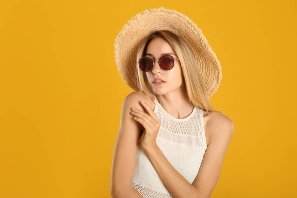 Beautiful woman in stylish sunglasses on yellow background - Φωτογραφία, εικόνα
