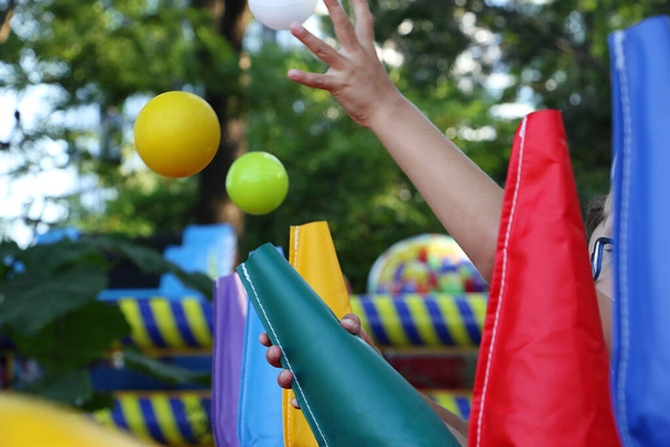 Il bambino cattura palloncini galleggianti in aria.Attrazione nel parco, fotografia da vicino. - Foto, immagini