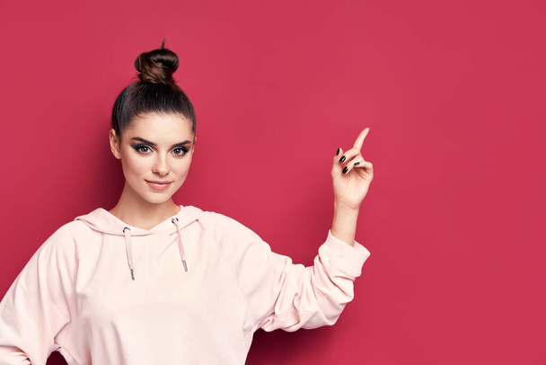 Молодая модная женщина показывает пальцем, чтобы скопировать пространство представляя продукт - Фото, изображение