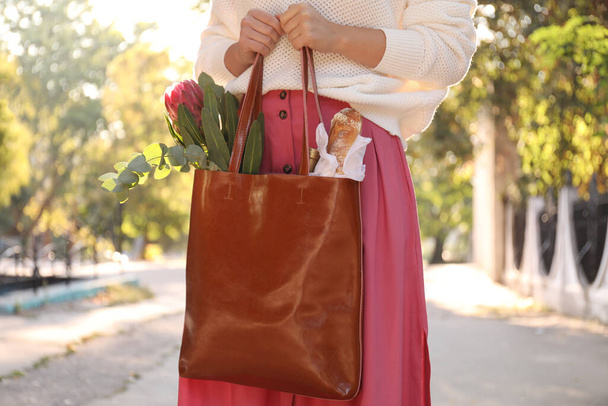 Woman with leather shopper bag outdoors, closeup - 写真・画像