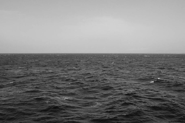Soğuk ve rüzgarlı bir günde derin deniz dalgaları ve gökyüzü ufku. Siyah ve beyaz. - Fotoğraf, Görsel