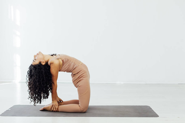 Beautiful female brunette yoga asana stretching the flexibility of body fitness sport - Foto, afbeelding
