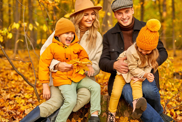 cheerful caucasian family have spare time in autumn park or forest - Fotó, kép