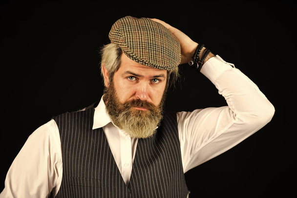 Fashion concept. bearded man hipster isolated on black. male vintage fashion. businessman farmer with dyed blonde beard. retro man in peaked cap. Portrait of mature man in victorian gangster outfit - Photo, image