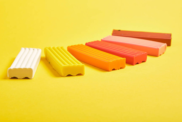 colored plasticine on yellow background copy space - Foto, imagen