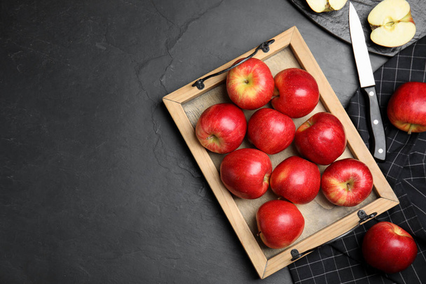 Fresh ripe red apples on black table, flat lay. Space for text - Foto, afbeelding
