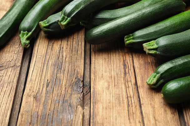 Green ripe zucchinis on wooden table, closeup. Space for text - 写真・画像