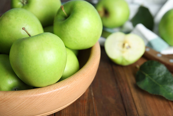 Fresh ripe green apples in bowl on wooden table, closeup. Space for text - Foto, Imagen