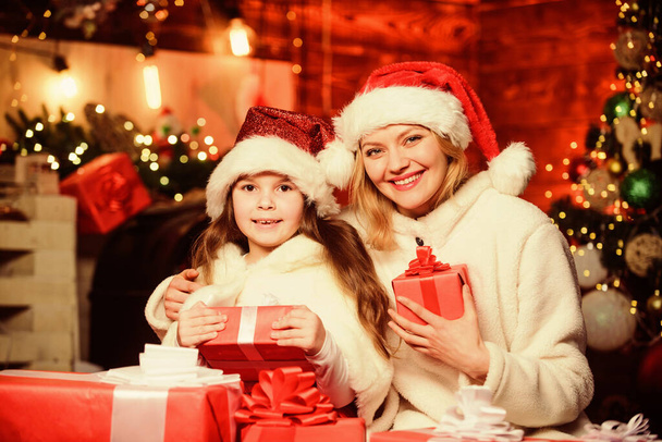 merry christmas. mother and daughter love holidays. xmas gift boxes. Open present. small child girl with mom in santa hat. Winter shopping sales. Happy family celebrate new year - Φωτογραφία, εικόνα