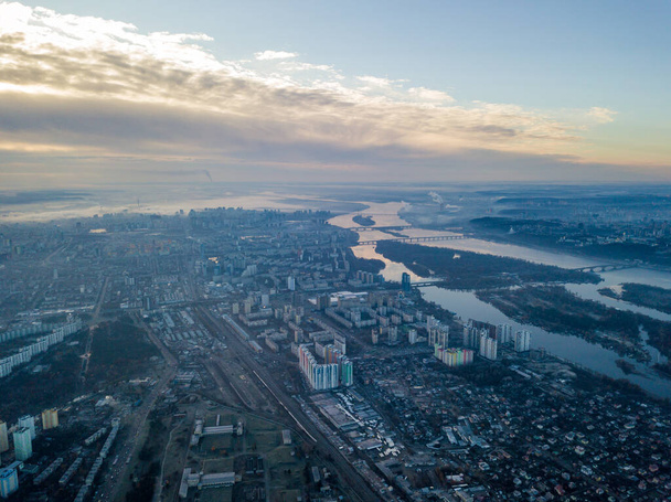 Aerial high flight over Kiev, haze over the city. Autumn morning, the Dnieper River is visible on the horizon. - Photo, Image
