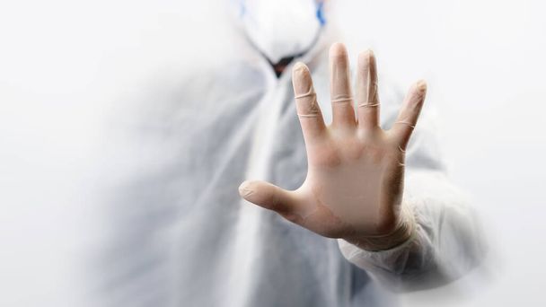 Orvos teljes test ruha és maszk mutatja stop tábla a kezét a fehér háttér. Corona vírus vagy covid-19 globális járvány - Fotó, kép