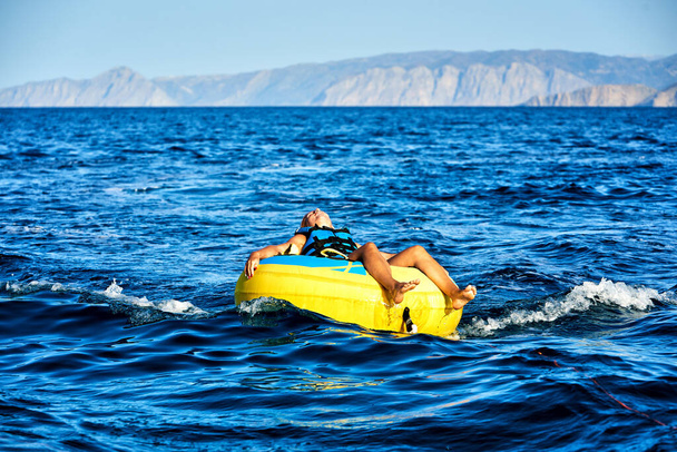 uomo rilassato sull'anello di gomma dell'acqua dopo la corsa in mare aperto - Foto, immagini