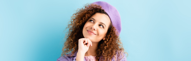 dreamy woman in beret looking away and smiling on blue, banner - Fotó, kép