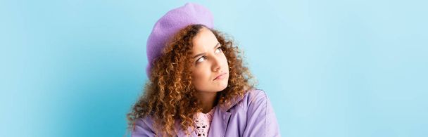 displeased woman in beret looking away on blue, banner - Foto, immagini