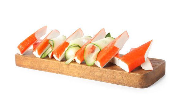 Wooden board with crab sticks and cucumber on white background - Zdjęcie, obraz