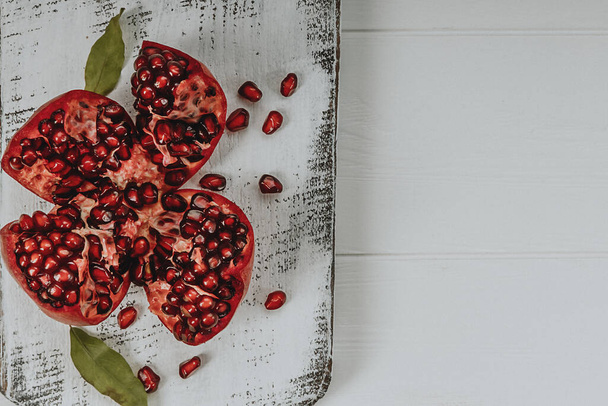 Christmas red pomegranate on a white wooden Board  - Photo, Image