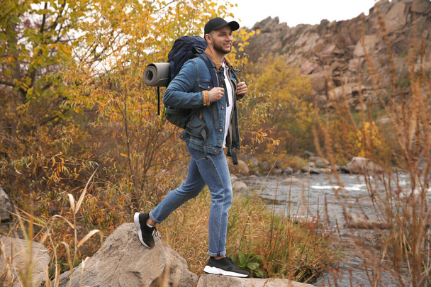 Man with backpack crossing mountain river on autumn day - Foto, immagini
