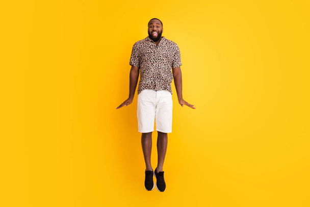 Full length body size view of his he nice handsome bearded childish playful comic funky cheerful cheery guy jumping having fun isolated on bright vivid shine vibrant yellow color background - Фото, зображення