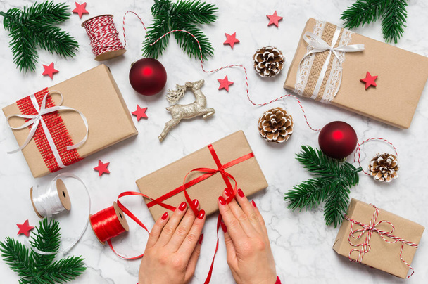 Noel hediyesini paketleyen kadın elleri. Kadın eli, hediye kutusu, takı ve dekorasyonla bayram hazırlığı. - Fotoğraf, Görsel