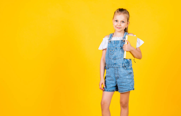 I know the answer. kid like reading. notebook for making notes. childrens literature. back to school. happy childhood. cute child on yellow background. education. beautiful teen girl with books - Fotografie, Obrázek