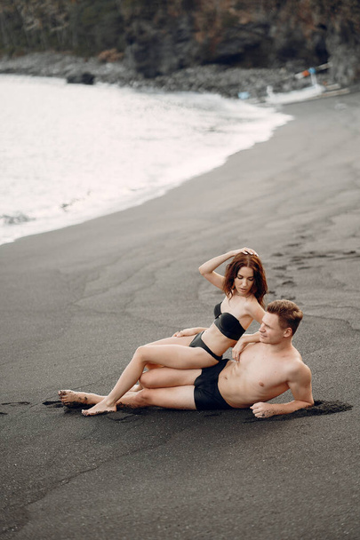 Elegant couple on a beach near rocks - Foto, Imagem