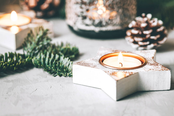Christmas decorations: candlesticks, fir branches and a garland on a gray background. - Φωτογραφία, εικόνα