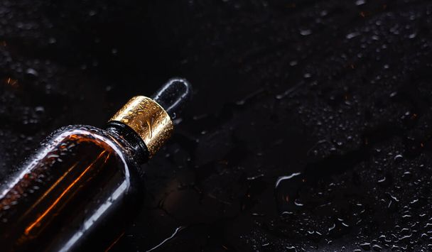 Butelka oleju do ciała na czarnym tle - Zdjęcie, obraz