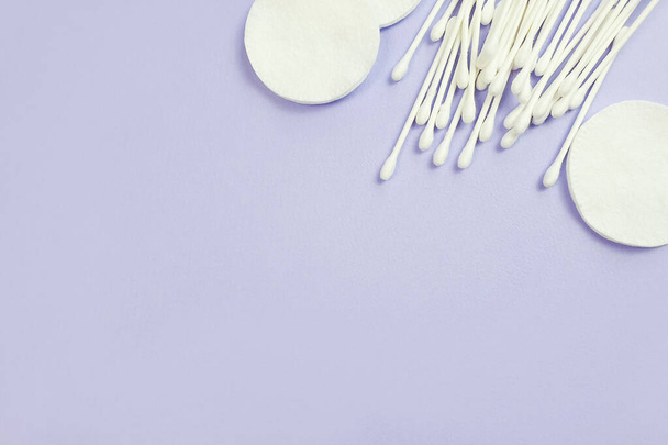 Cotton pads and sticks on light purple background. Top view, empty place for product or text. Flatlay style - Foto, afbeelding