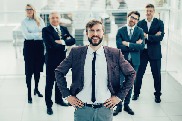 smiling business man standing in front of the business team - Foto, imagen