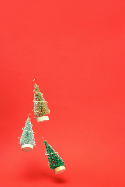 Fondo de Navidad. Otoño de árbol de invierno plateado, dorado y verde con luces brillantes en composición de Navidad sobre fondo rojo oscuro para tarjeta de felicitación. Copiar espacio. Vacaciones de invierno - Foto, Imagen