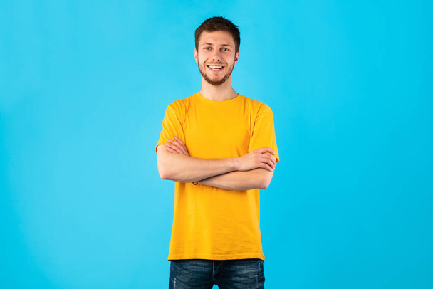 Confident man posing with folded arms and looking at camera - Фото, зображення