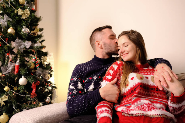Young happy couple men and women kissing sitting on the sofa. - Valokuva, kuva