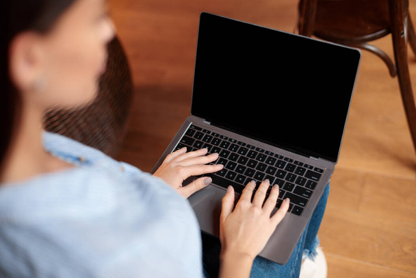 Femme utilisant un ordinateur portable avec écran de maquette vierge, tapant sur le clavier - Photo, image