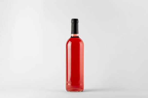 Red wine bottle with rose wine isolated on white - Fotoğraf, Görsel