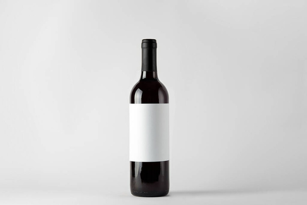 Black wine bottle with red wine isolated on white - Fotoğraf, Görsel