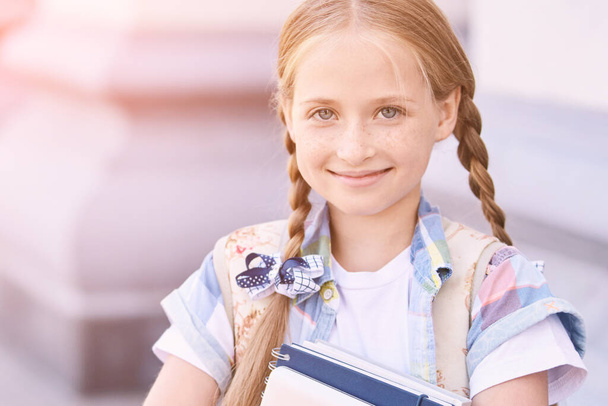 Beautiful american portrait of schoolgirl. Preschool kid holding book. Smiling - Фото, зображення
