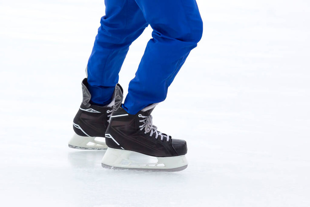 jambes d'un patineur sur une patinoire. passe temps et loisirs. sports d'hiver - Photo, image