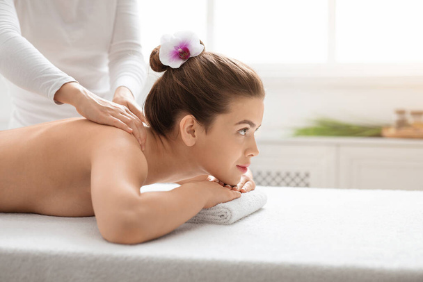 Mulher nua bonita frequentando salão de spa, recebendo de volta massagem - Foto, Imagem