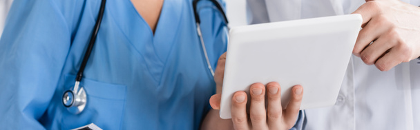 Vue recadrée du médecin et de l'infirmière à l'aide d'une tablette numérique en clinique, bannière  - Photo, image